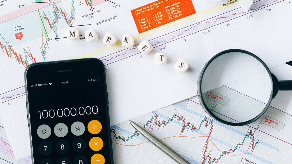 Calculator and magnifying glass on printed crypto diagrams