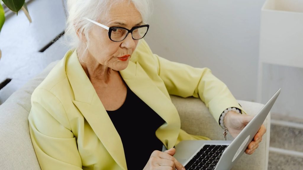 Old lady in deep thought holding a laptop